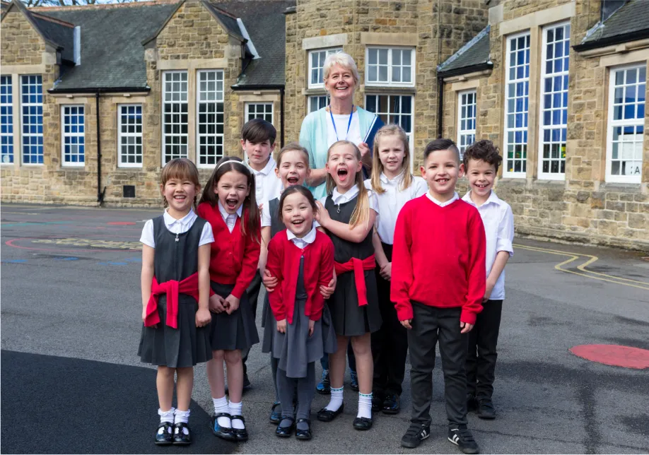 An image of schoolchildren outside with an apprentice TA